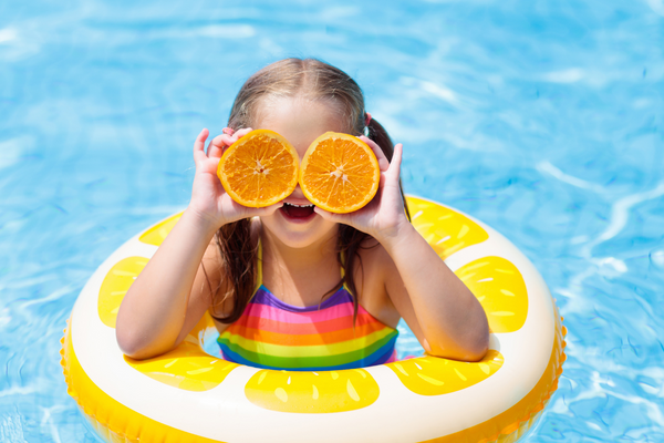 Child enjoying a bright blue municipal swimming pool treated with pool chemicals