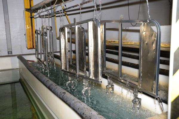 Metal parts dripping from industrial electroplating bath