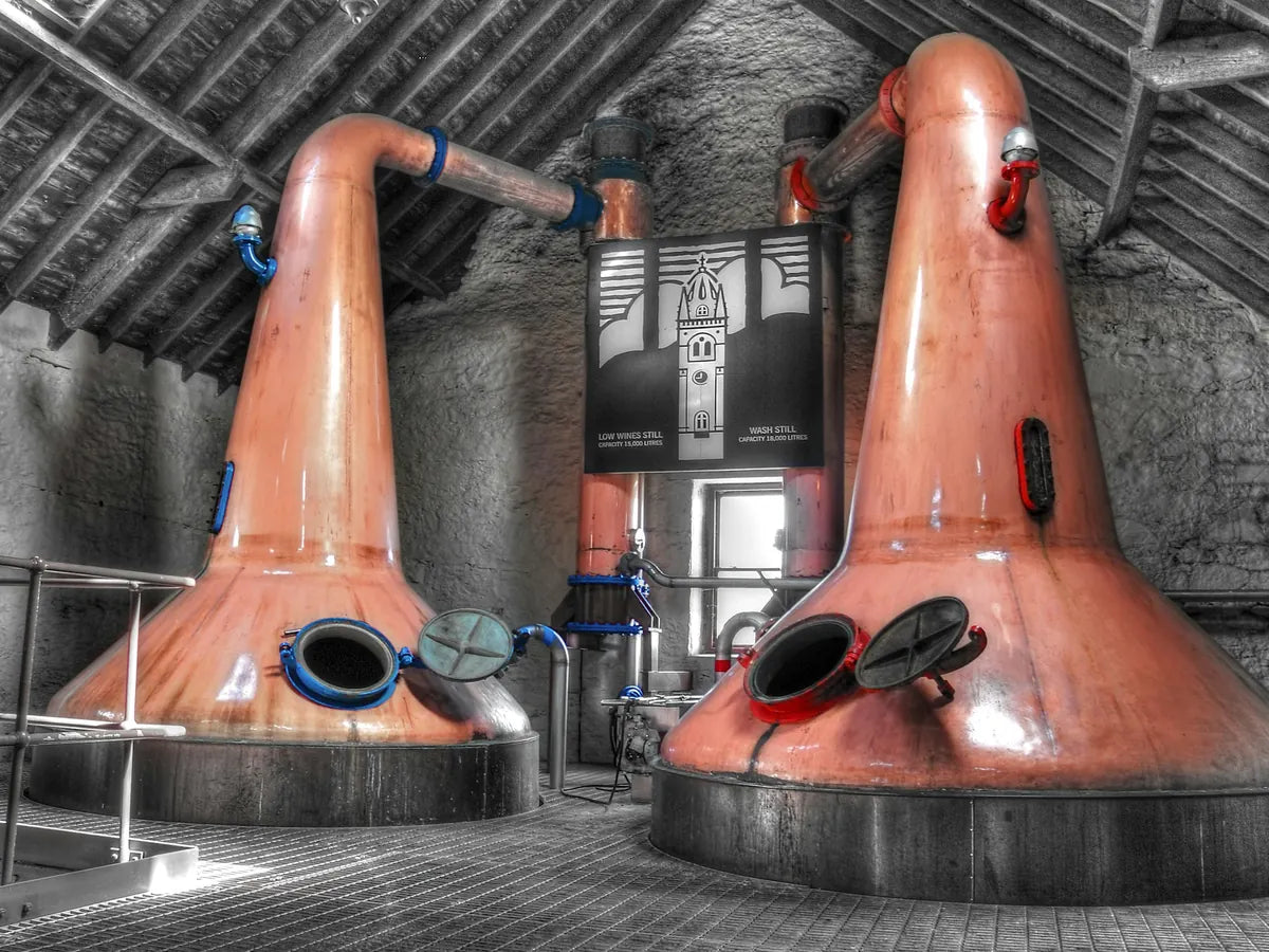 Two copper pot stills in a distillery