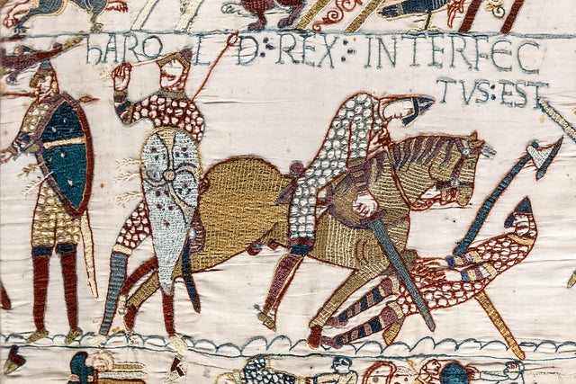 Bayeux Tapestry scene 57, the death of King Harold: embroidered soldiers in red, yellow and blue-green wool on linen, one figure gripping a shaft near his eye beneath the Latin inscription Harold Rex interfectus est