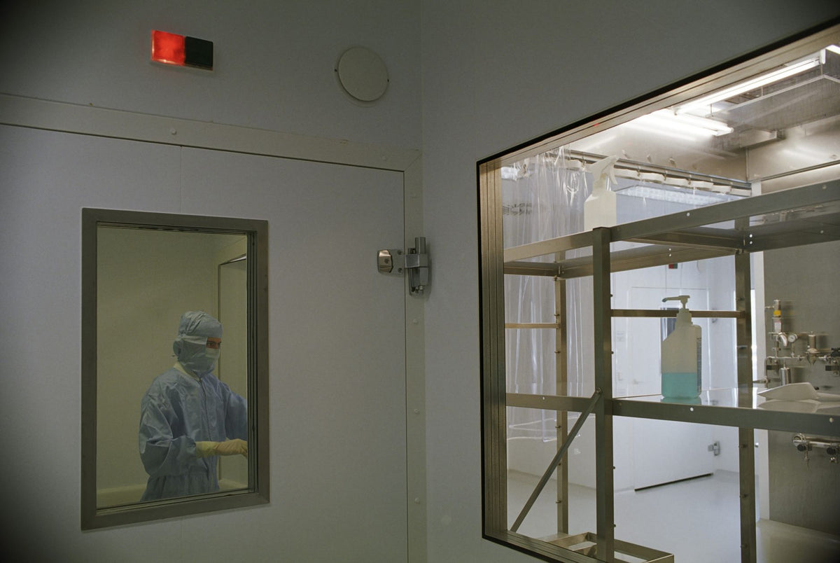 Image of a cleanroom in a medical facility featuring sterile equipment and a person in protective clothing.