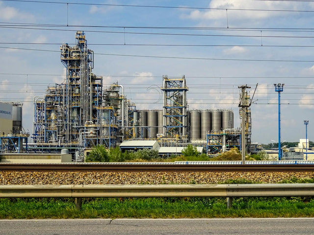 Image of a large chemical factory in Schwechat, Austria, showcasing industrial pipes and machinery.