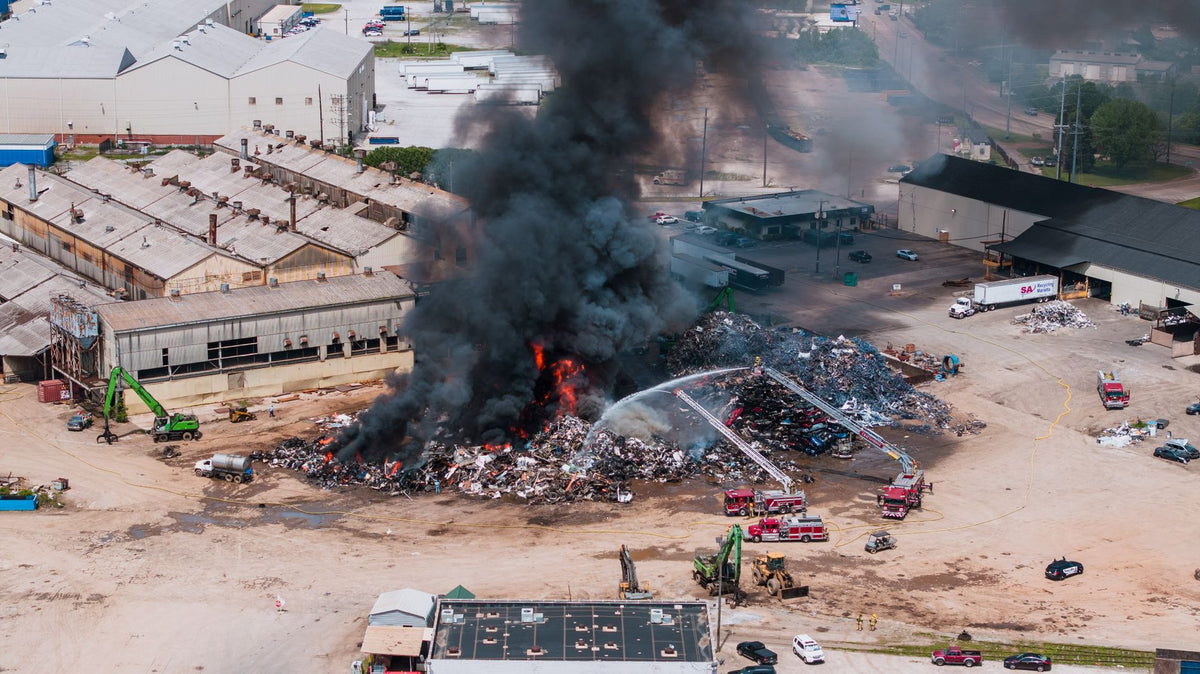 Aerial shot of a large industrial fire with black smoke and fire engines in Chattanooga, TN.