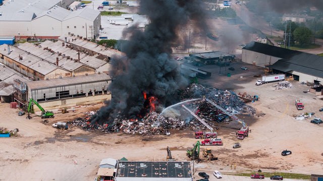 Aerial shot of a large industrial fire with black smoke and fire engines in Chattanooga, TN.