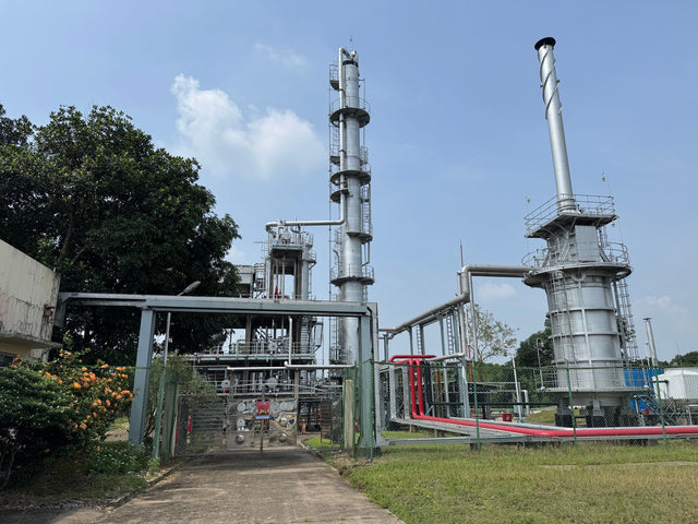 A large industrial plant outdoors with metal structures and clear blue sky.