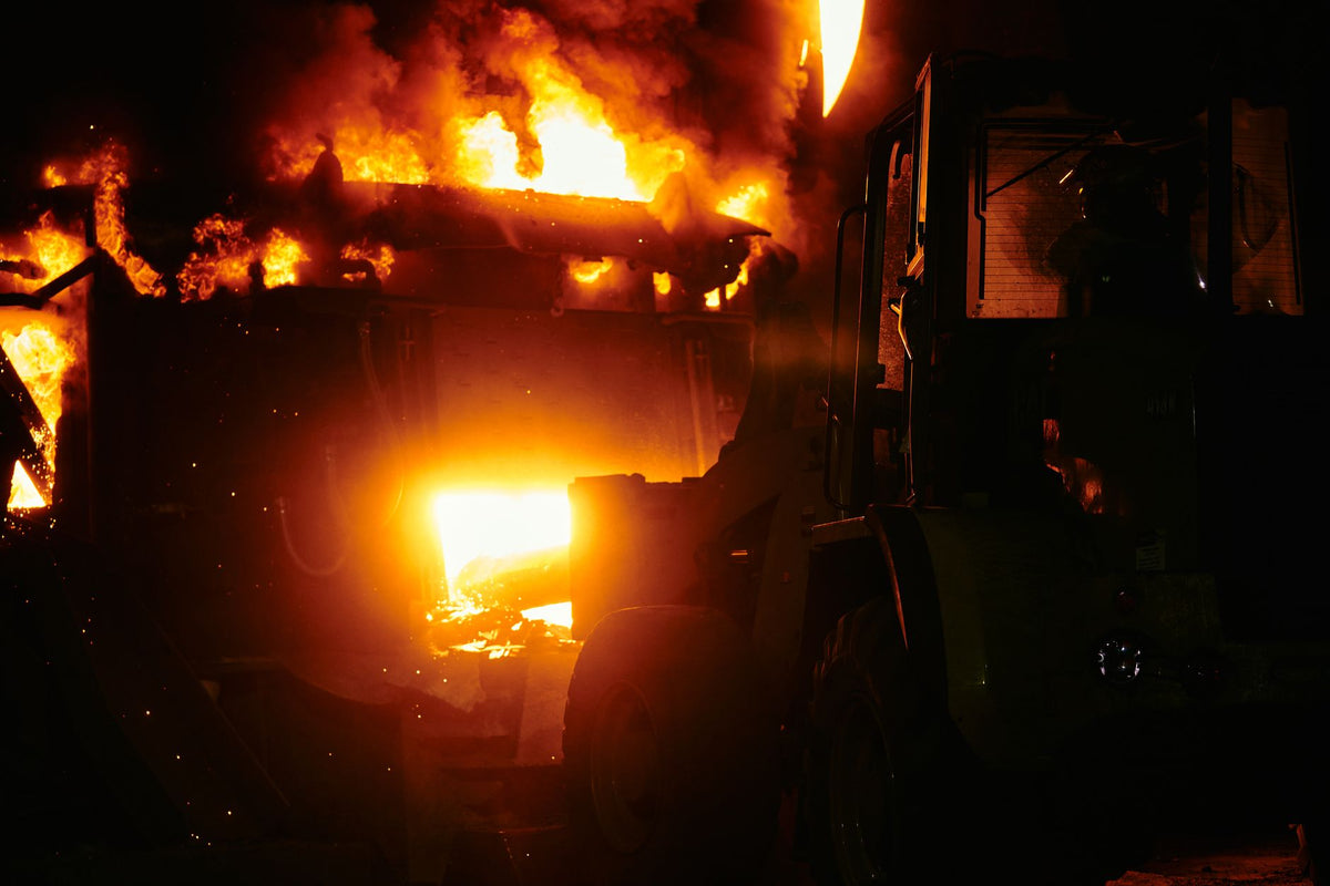A dramatic scene of an industrial fire blazing fiercely at night.