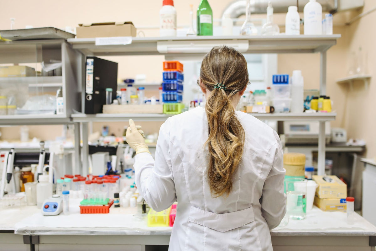 A female scientist conducting research in a well-equipped laboratory, focusing on chemical analysis.