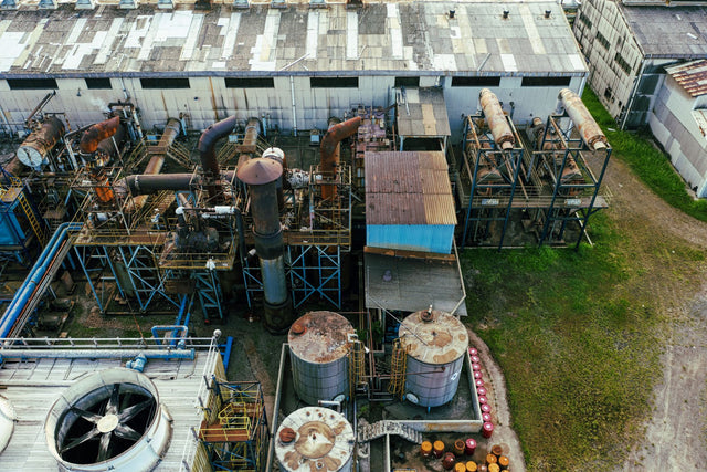 Drone view of industrial area with barrels for petroleum products and pipes connected with warehouses