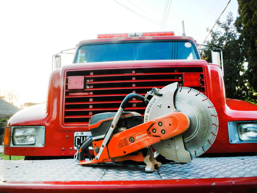 Focused shot of a concrete saw on a red firetruck, showcasing emergency rescue tools.