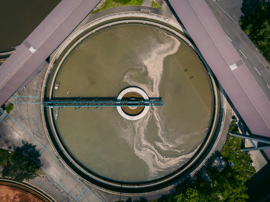 Aerial view of a circular wastewater treatment basin at a sewage treatment plant