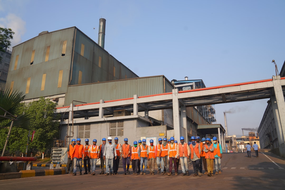 a group of people in orange vests standing in front of a building