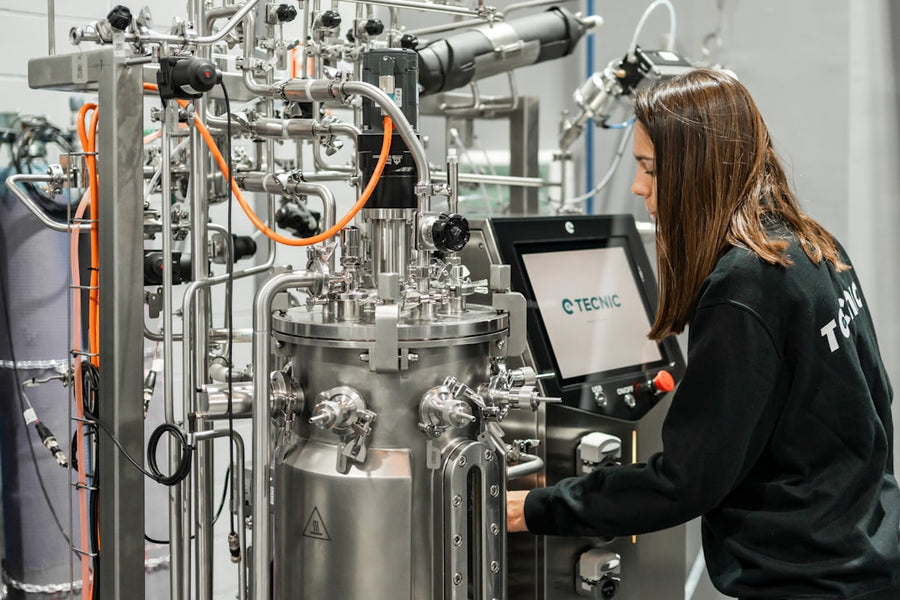 A woman operates complex scientific equipment.