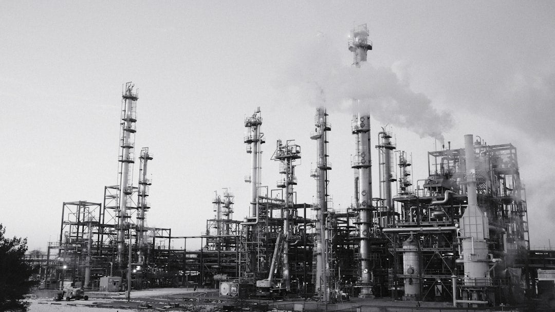 Industrial refinery with smoking stacks under a cloudy sky