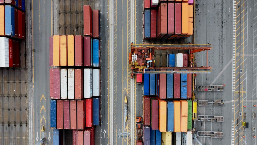 Aerial view of stacked shipping containers at a port.