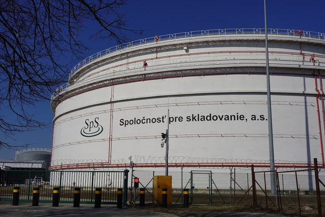 Large industrial storage tanks under a clear blue sky