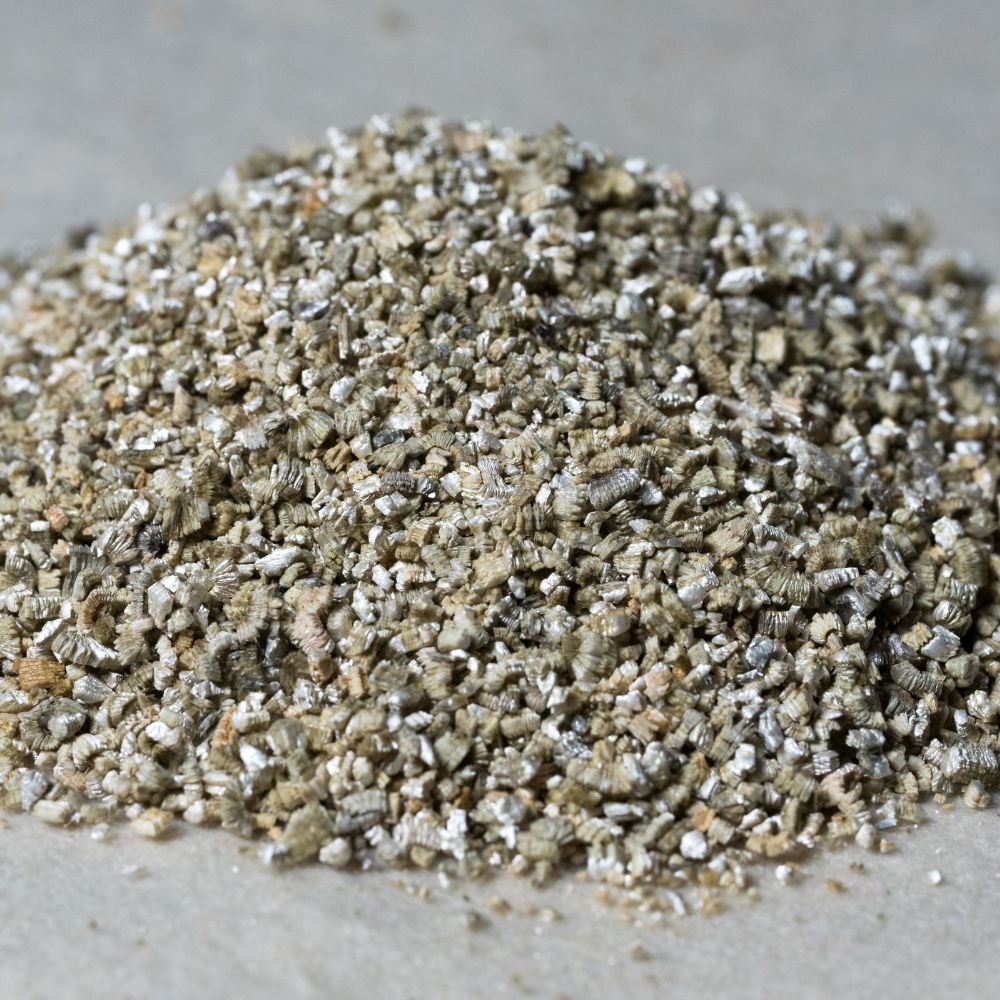 Fine-grade organic vermiculite mineral aggregate, showing silver-gray expandable mica particles with layered structure and varied granulation size 1-3mm.