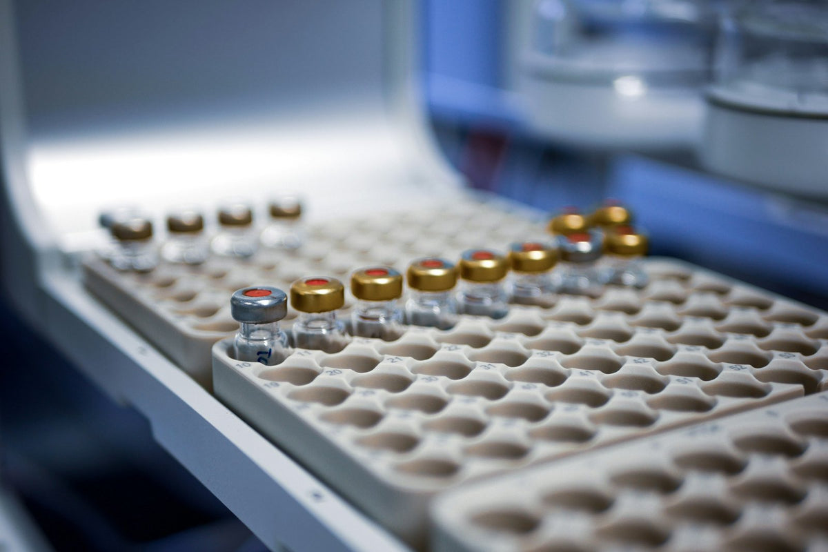 Capped glass sample vials in a numbered tray inside a laboratory instrument