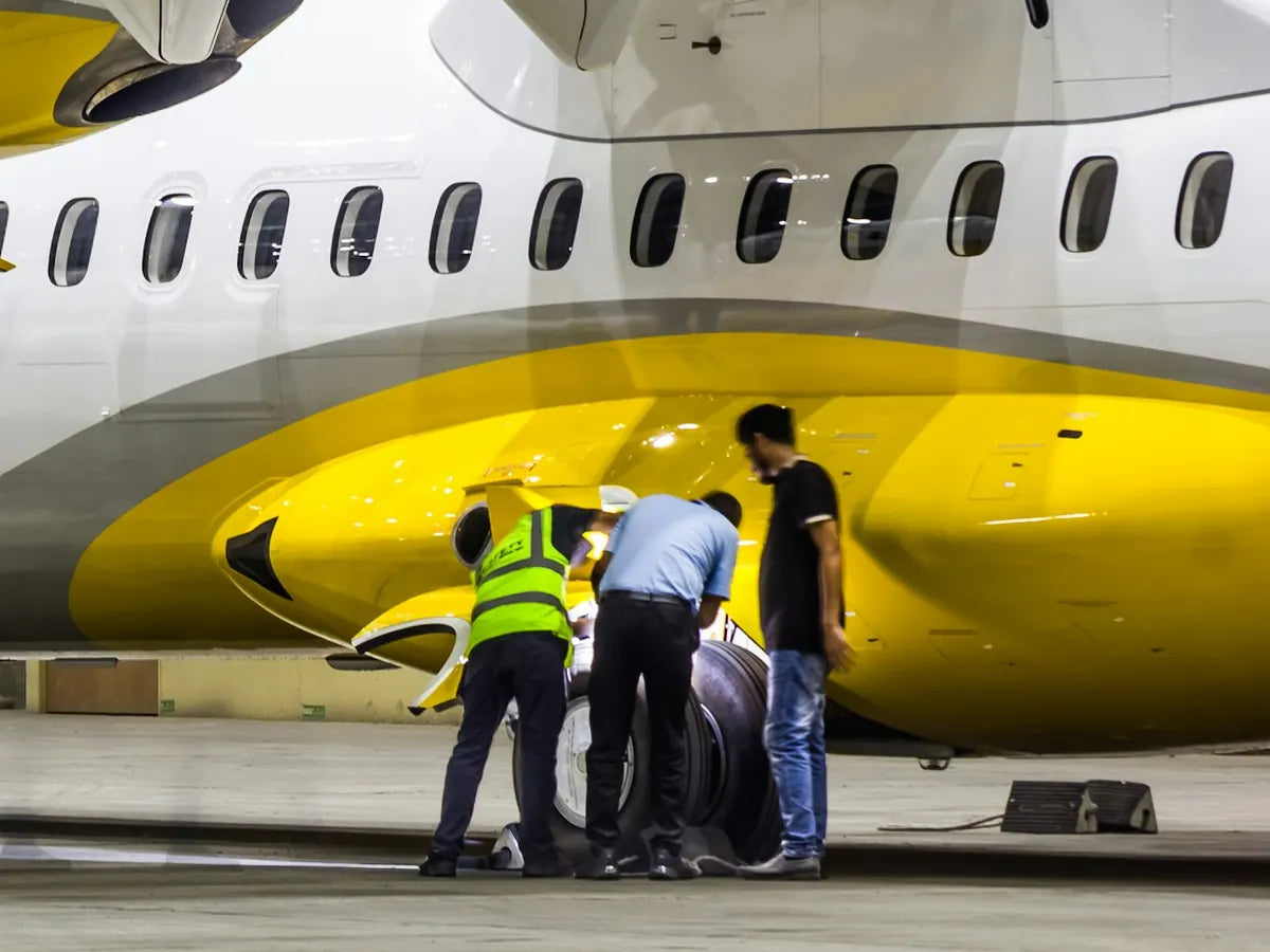 Technicians inspecting an aircraft's landing gear in a hangar